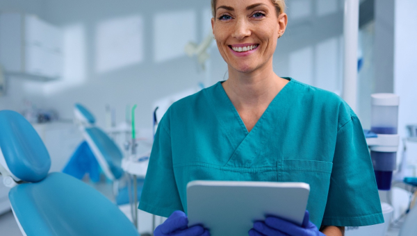 A happy dentist holding the OrthoPhoto dental recordkeeping app